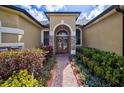 Inviting front entrance featuring beautiful glass double doors, stone accents, and mature landscaping at 2626 Greenwillow Dr, Orlando, FL 32825