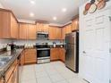 Bright kitchen with stainless steel appliances, granite countertops, and white tiled floors at 332 Blue Lake Cir, Kissimmee, FL 34758