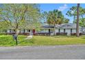 Charming single-story home with a well-manicured lawn, mature landscaping, and a brick facade at 401 Sanford Ave, Longwood, FL 32750