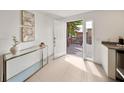 Bright foyer featuring tile floors, a glass console table, and a white front door at 506 S Hyer Ave, Orlando, FL 32801