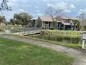 Scenic community featuring charming condominium buildings near a serene pond with a walkway at 5926 Peregrine Ave # A13, Orlando, FL 32819