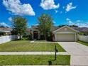 Lovely home with a well-kept lawn, mature trees, and an attached two-car garage at 610 Carey Way, Orlando, FL 32825