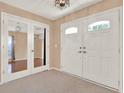 Bright foyer featuring double doors, carpet, and neutral walls, creating a welcoming entry at 650 Sweetbriar Br, Longwood, FL 32750