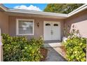 Inviting front entrance with white double doors, complemented by lush landscaping and a bright window at 650 Sweetbriar Br, Longwood, FL 32750