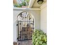 Charming arched gate leading to a private courtyard with brick pavers at 7629 Chapelhill Dr, Orlando, FL 32819