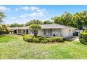 Beautiful home showcasing the manicured lawn, trimmed bushes, and two-car garage, all under a bright blue sky at 901 Golfside Dr, Winter Park, FL 32792