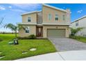 Contemporary two-story home featuring a red front door, a two-car garage, and a well-maintained lawn at 905 Ocean Course Ave, Davenport, FL 33896