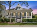 Charming home with inviting porch, decorative gable, and manicured hedges at twilight at 931 Croton Rd, Celebration, FL 34747