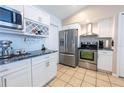 Modern kitchen featuring white cabinets, stainless steel appliances, and granite countertops at 1060 Elkcam Blvd, Deltona, FL 32725