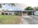 Inviting single-story home with a convenient carport and lush green lawn at 1118 Arrowsmith Ave, Orlando, FL 32809