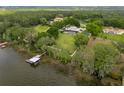 Expansive waterfront property featuring a luxurious home, pool, private dock, and lush landscaping at 11200 Lane Park Rd, Tavares, FL 32778