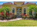 Inviting home entrance with double doors, complemented by colorful plants and manicured lawn at 12614 Hawkstone Dr, Windermere, FL 34786
