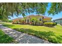 Well-maintained yellow home featuring vibrant landscaping and a sprawling green lawn at 12614 Hawkstone Dr, Windermere, FL 34786
