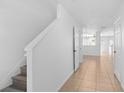 Bright hallway with tile flooring leading to the living spaces and staircase at 131 Heritage Park St, Winter Springs, FL 32708