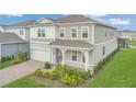 Aerial view of a two-story home with a neutral color palette, landscaping, and brick driveway at 13640 Haulover Beach Ln, Orlando, FL 32827