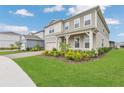 Side view of a two-story home with a well-manicured lawn and complementary landscaping at 13640 Haulover Beach Ln, Orlando, FL 32827