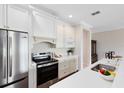 Well-equipped kitchen features stainless steel appliances, white cabinets, and quartz countertops at 1561 Corkery Ct, Winter Springs, FL 32708