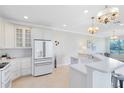 Well-lit kitchen featuring sleek white cabinets, modern appliances, a tile floor, and an open design at 1565 Corkery Ct, Winter Springs, FL 32708