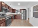 Modern kitchen featuring stainless steel appliances, dark wood cabinets, and tiled flooring at 1725 Marcia Dr, Orlando, FL 32807