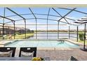 Relaxing screened-in pool with a serene lake view, inviting you to unwind in the refreshing water at 1864 Nice Ct, Kissimmee, FL 34747