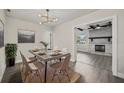 Modern dining room with stylish light fixture, gray-toned wood floors, and view to the living room at 2015 N Hastings St, Orlando, FL 32808
