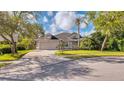 Charming single-Gathering home featuring a paver driveway, attached garage, and lush landscaping at 203 Red Bud Ct, Lake Mary, FL 32746