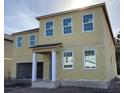 Two-story home featuring a neutral beige siding, white trim, large windows, and a two-car garage at 2286 Broadbrook Dr, St Cloud, FL 34771