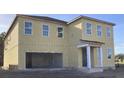 Two-story home featuring a neutral beige siding, white trim, large windows, and a two-car garage at 2286 Broadbrook Dr, St Cloud, FL 34771