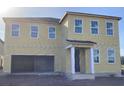 Two-story home featuring a neutral beige siding, white trim, large windows, and a two-car garage at 2286 Broadbrook Dr, St Cloud, FL 34771