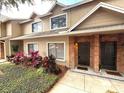 Inviting townhome with well-maintained landscaping and brick accents around the front door at 255 Sandlewood Trl, Winter Park, FL 32789