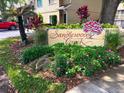 Sandlewood Creek community sign surrounded by lush, colorful landscaping and mature trees at 255 Sandlewood Trl, Winter Park, FL 32789