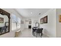 Bright dining area with tiled floors, modern table set, and stylish wall decor at 2827 Turnstone Run, Harmony, FL 34773