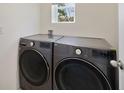 Modern laundry room with gray LG front-loading washer and dryer at 2827 Turnstone Run, Harmony, FL 34773