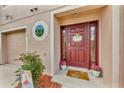 Inviting entryway with a decorative front door, welcome mat, and potted plants, adding a touch of charm at 2914 Clarabelle Ct, Kissimmee, FL 34743