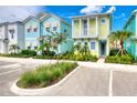 Colorful two-story coastal cottages with pastel exteriors, balconies, blue shutters, lush landscaping, and parking at 2978 Latitude Ln, Kissimmee, FL 34747