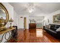 Bright living room with hardwood floors, a ceiling fan, a comfortable leather sofa, and a front door at 3536 Moss Pointe Pl, Lake Mary, FL 32746