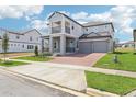 Two-story home showcasing a two-car garage, a cozy balcony, and landscaped front lawn at 5260 Citrus Leaf Blvd, Winter Garden, FL 34787