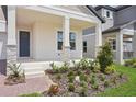 Inviting covered front porch with stone accents and meticulously landscaped front yard at 5290 Citrus Leaf Blvd, Winter Garden, FL 34787