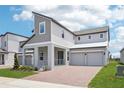 Charming modern two-story home featuring a brick driveway and covered porch with metal railing at 5307 Citrus Leaf Blvd, Winter Garden, FL 34787