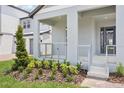 Inviting covered front porch with modern metal railing and landscaped garden at 5307 Citrus Leaf Blvd, Winter Garden, FL 34787