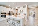 Bright, open-concept kitchen featuring stainless steel appliances, a central island with seating and pendant lighting at 553 Moon Shell Cir, New Smyrna Beach, FL 32168