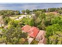 Stunning aerial view showcasing the property's tile roof and lush surroundings near a beautiful lake at 7 Forest Ln, Eustis, FL 32726