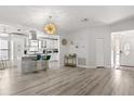 Bright open-concept living area featuring wood floors, modern lighting, and a stylish kitchen view at 7 Forest Ln, Eustis, FL 32726