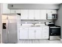 Well-lit kitchen featuring white cabinets, stainless steel appliances, and modern fixtures at 734 Michigan Ct # 2, St Cloud, FL 34769