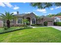 Charming home features a tile roof, manicured lawn and two car garage at 7672 Torino Ct, Orlando, FL 32835