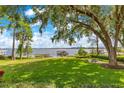 Lush backyard with a scenic lake view, featuring a well-maintained lawn, mature trees, and a charming dock at 10577 Down Lakeview Cir, Windermere, FL 34786