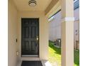 Inviting front entrance featuring a black door, neutral walls, and a covered porch area at 1920 Commander Way, Kissimmee, FL 34746