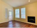 View of bright living room with wood floors, fireplace, and large windows at 1980 Erving Cir # 107, Ocoee, FL 34761