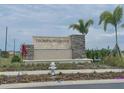 An inviting community sign with stone accents, set amidst lush landscaping and palm trees at 2232 Tay Wes Dr, St Cloud, FL 34771