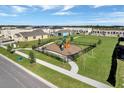 A community playground with modern equipment is surrounded by a fence and well-maintained green space at 2232 Tay Wes Dr, St Cloud, FL 34771